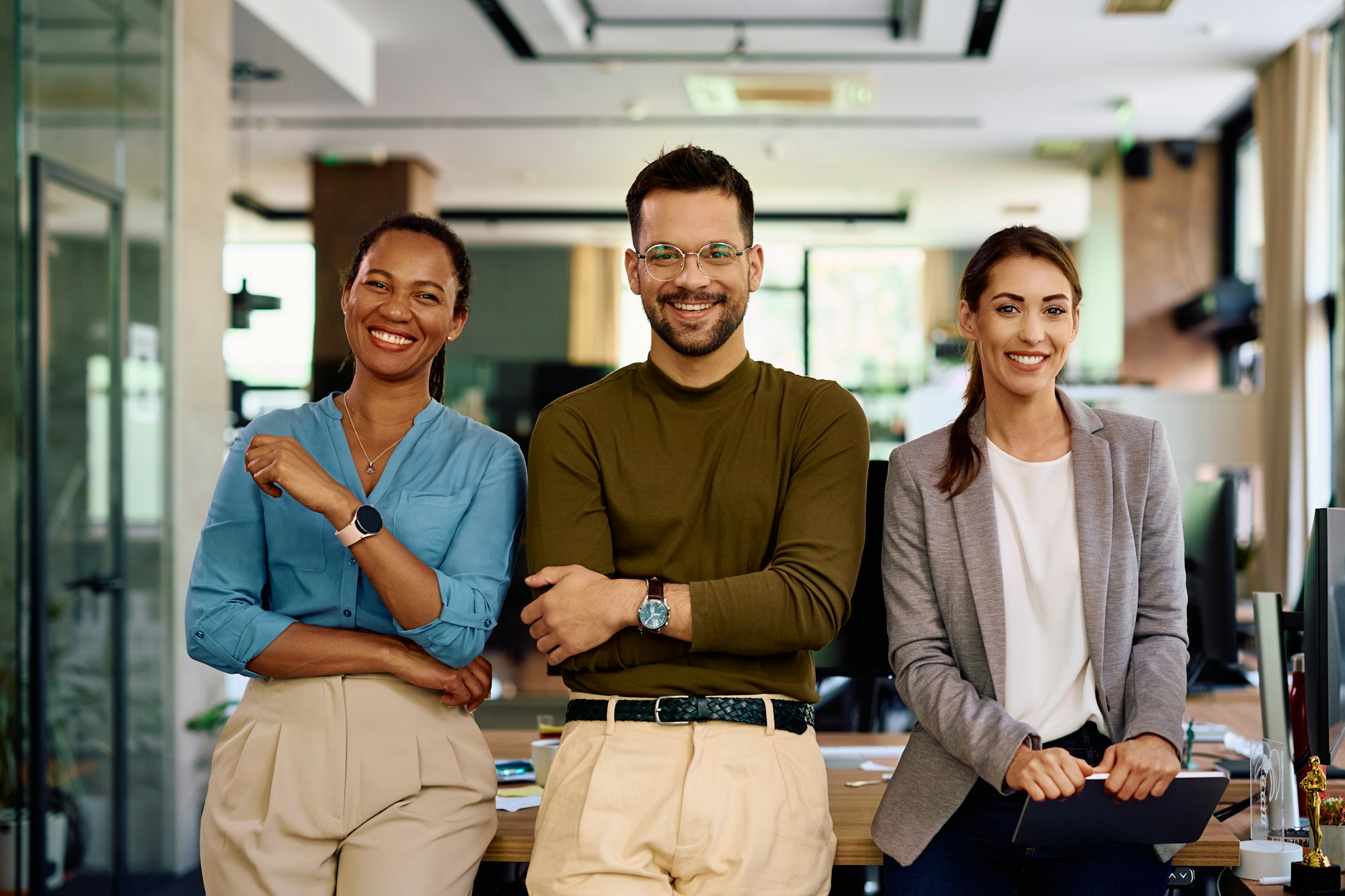 Happy business team in modern office looking at camera.